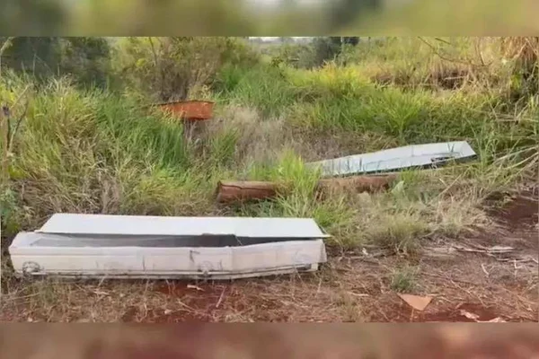 Imagem colorida de caixões jogados em terreno - Metrópoles