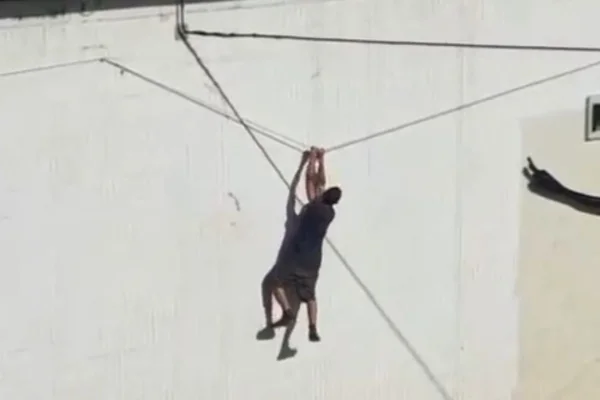 Pendurado em fiação, homem escala muro do Buraco do Tatu e foge da PM