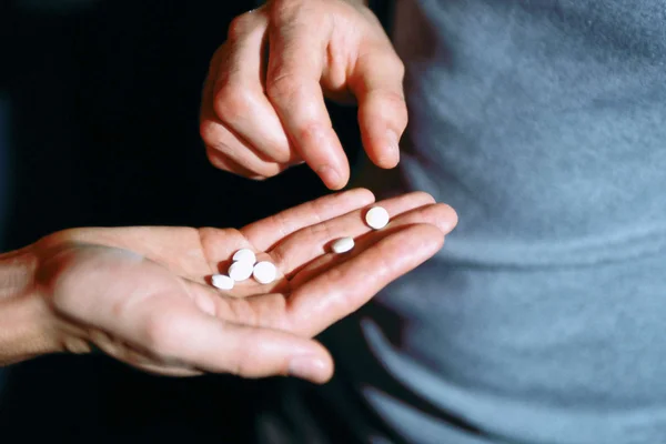 Foto mostra homem oferecendo comprimidos de ecstasy MDMA