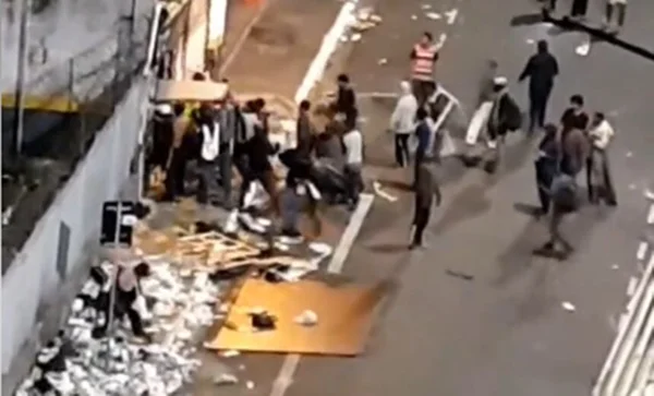 Em foto colorida usuários de droga usam porta de armário pra arrombar comércio - Metrópoles