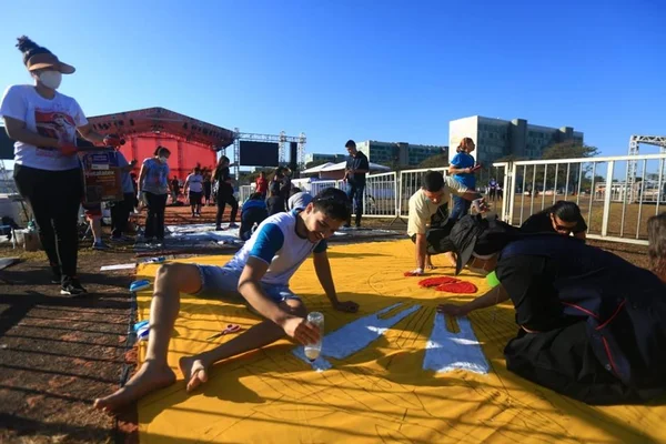 foto colorida de tapete de Corpus Christi sendo confeccionado na Esplanada dos Ministérios
