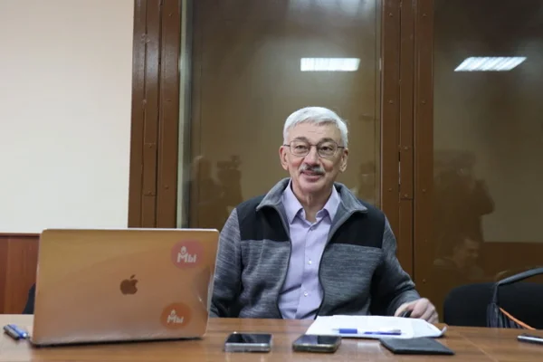 O ativista antiguerra russo Oleg Orlov está sentado em um tribunal do Tribunal Distrital de Golovinsky, em Moscou. Começou um novo julgamento contra Orlov, no qual ele enfrenta prisão