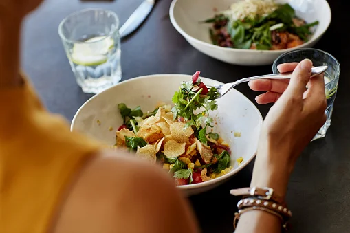 imagem colorida de mulher comendo salada - Metrópoles