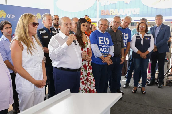 Homem com microfone rodeado de pessoas