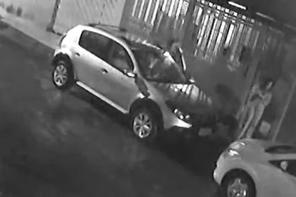 Imagem preto e branco de casa com portão aberto