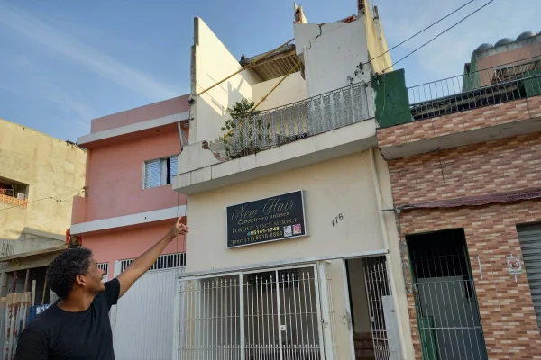 Imagem mostra homem apontando parede destruída - Metrópoles