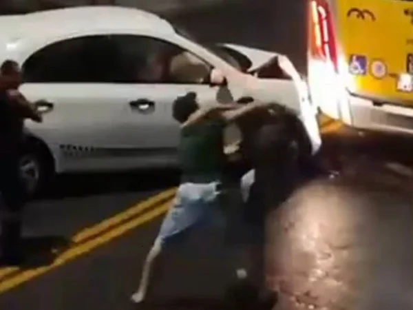 Imagem colorida mostra dois homens trocando socos no meio da rua em Itaquera, na zona leste de São Paulo - Metrópoles