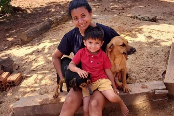 Imagem colorida de menino com cachorros - Metrópoles