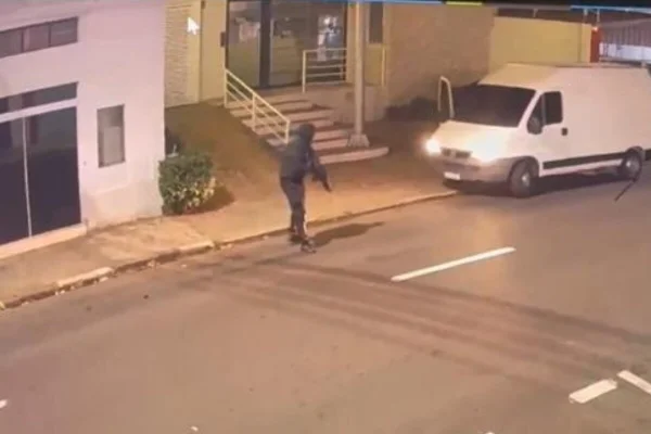 Homem vestido de preto, com fuzil, no meio da rua - Metrópoles