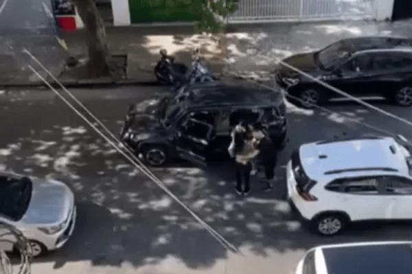 Imagem colorida de três pessoas ao redor de um Jeep preto após uma briga de trânsito - Metrópoles