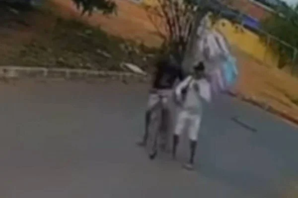 Foto colorida do momento em que o ladrão tenta roubar o varal de algodão doce de um vendedor
