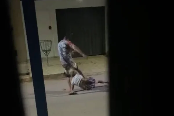 homem chuta mulher que está no chão