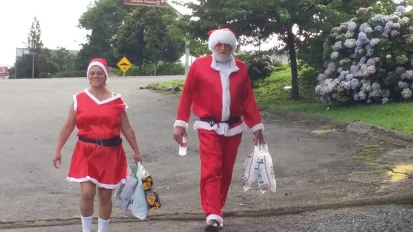 Casal fantasiado de Mamãe Noel e Papai Noel