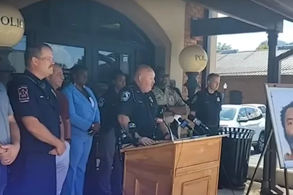imagem colorida mostra coletiva de imprensa com policiais usando fardas em frente a pulpito