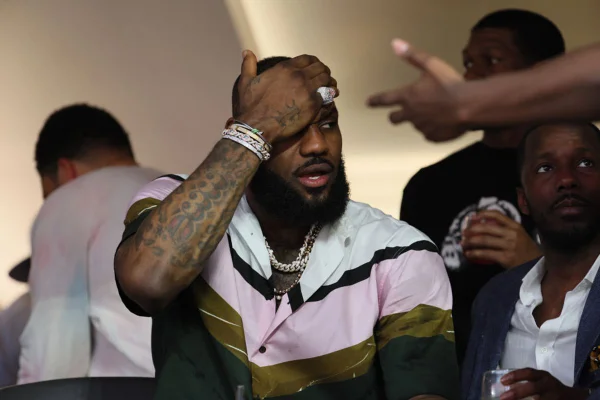LeBron James sentado com a mão na testa durante jogo do Superbowl