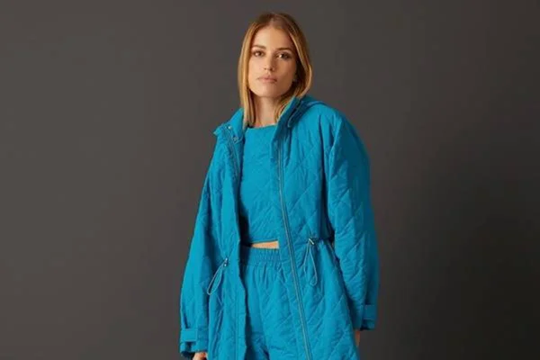 Modelo usa casaco e calça azul
