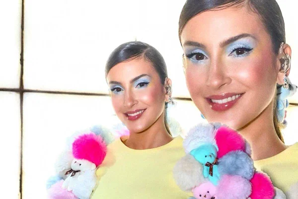 Claudia Leitte maquiada de azul, com blusa bufante e colorida - Metrópoles