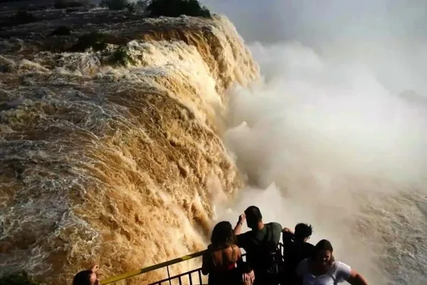 Foto colorida de turistas em mirante nas Cataratas do Iguaçu - Metrópoles