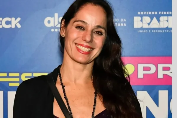 Claudia Mauro posa sorridente nos bastidores de um evento - Metrópoles