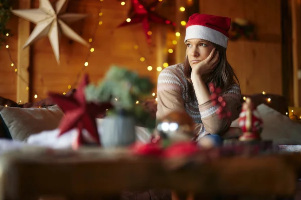 Mulher triste com chapéu de papai Noel - Metrópoles