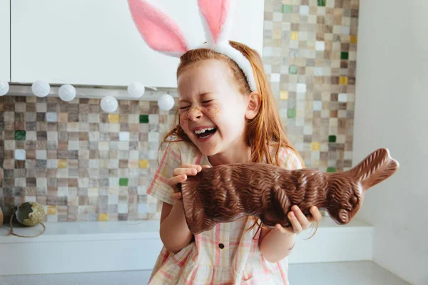 criança feliz na pascoa com coelho de chocolate