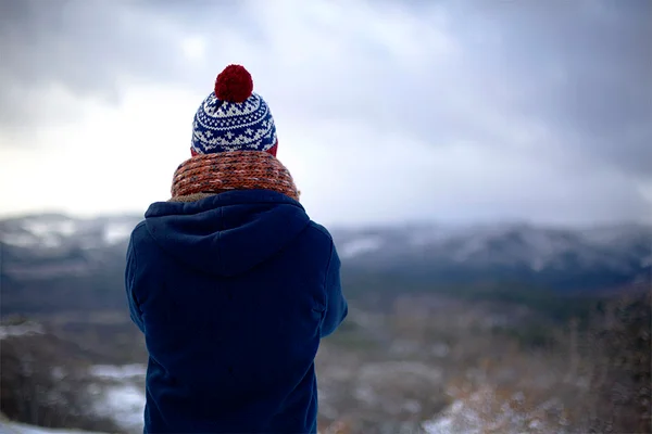 Mulher contempla paisagem no frio