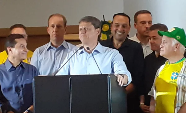 Tarciso dando uma entrevista coletiva ao redor de aliados