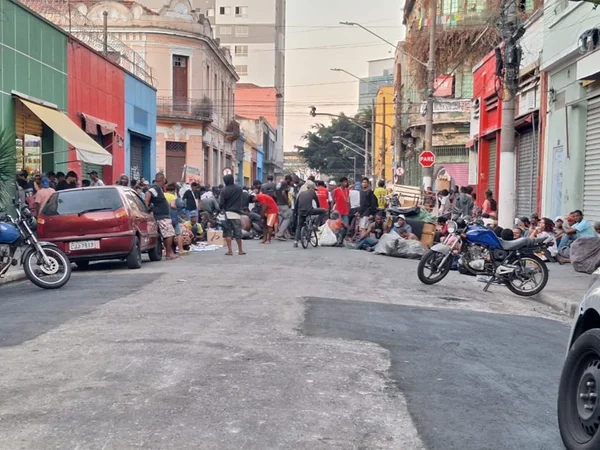 Imagem colorida mostra rua do centro de SP repleta de pessoas consumindo drogas - Metrópoles