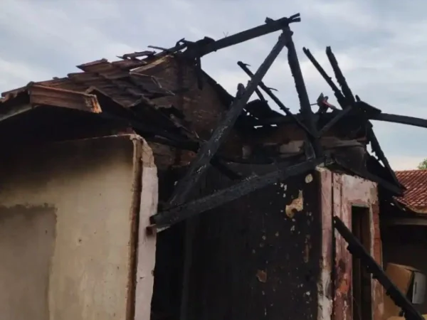 Foto colorida mostra escombros de casa após incêndio