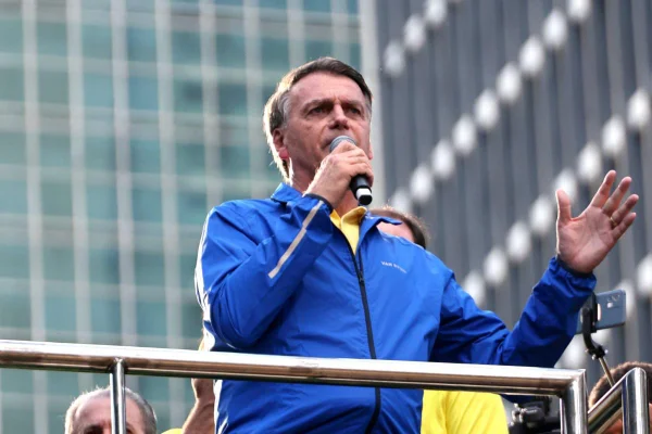 Jair Bolsonaro em manifestação Avenida na Paulista. Vestido de azul, ele segura um microfone - Metrópoles