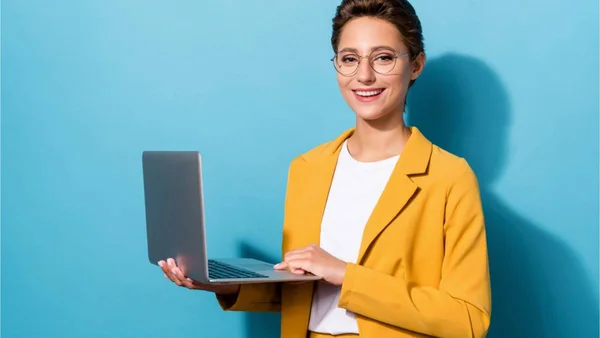 Mulher com um notebook na mão em um fundo azul