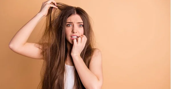 Mulher branca com a mão no cabelo