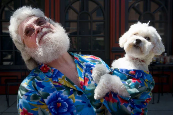 Imagem colorida de idoso carregando cachorro