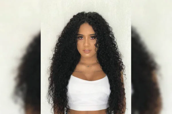 Jovem negra com cabelo solto e blusa branca - Metrópoles