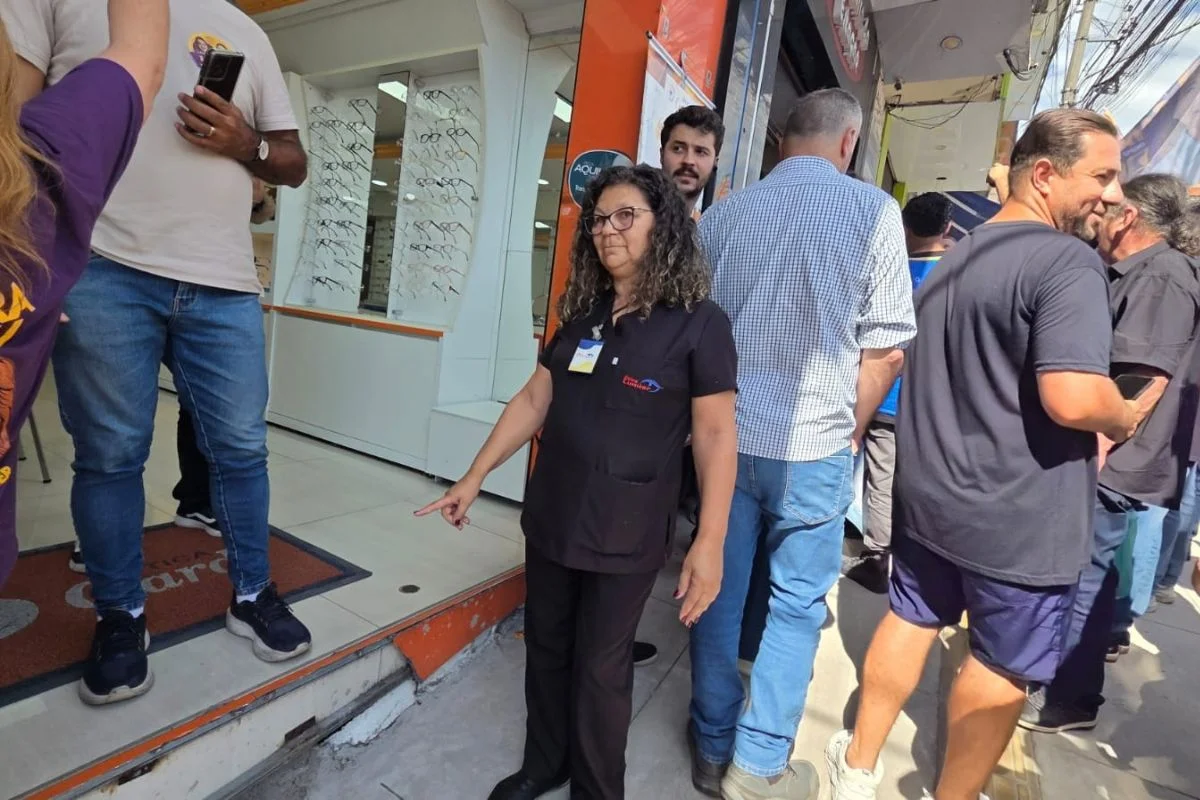 Vendedora mostra desnível e fachada quebrada na entrada de loja Vendedora mostra desnível e fachada quebrada na entrada de loja