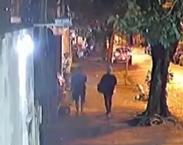 Imagem de câmera de segurança mostra duas mulheres caminhando em calçada à noite - Metrópoles