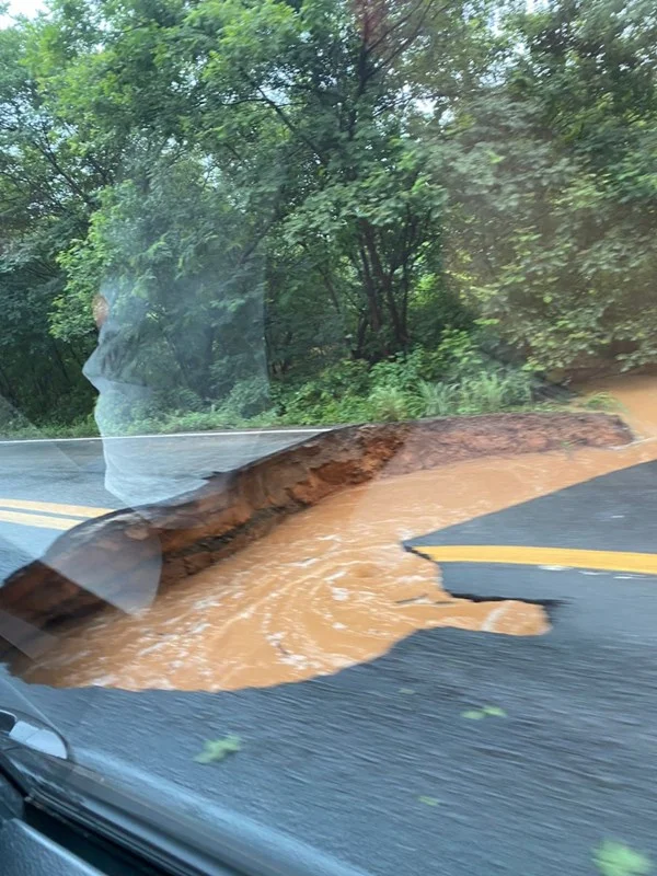 Cratera aberta na estrada, coberta por água barrenta