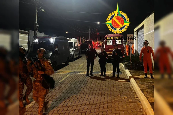 Foto colorida de rua com policiais e viatura