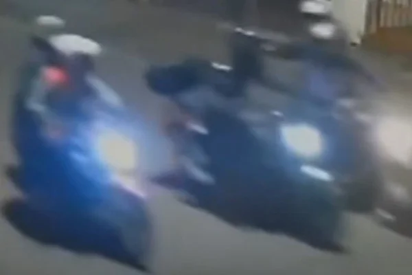 Imagem colorida de suspeitos com arma na cabeça de homem, através do capacete. Metrópoles