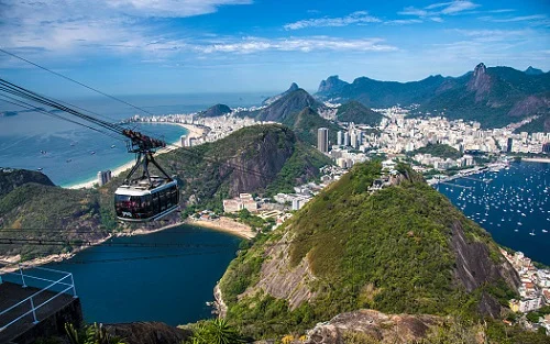 cidade vista de morro com veiculo sobre trilhos