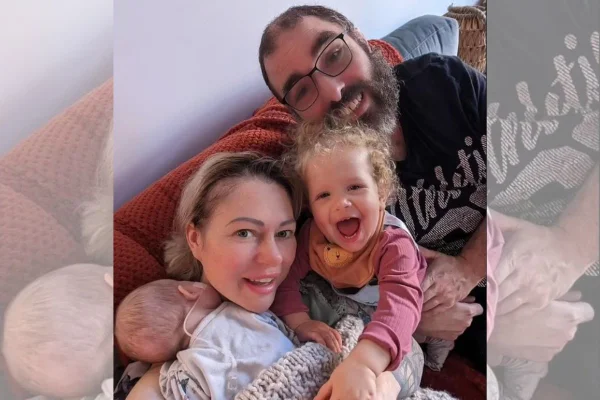 Foto de mulher abraçada com bebê e menina ao lado de homem - Metrópoles