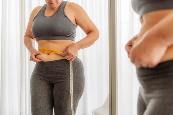 Mulher medindo a barriga com fita métrica - Metrópoles
