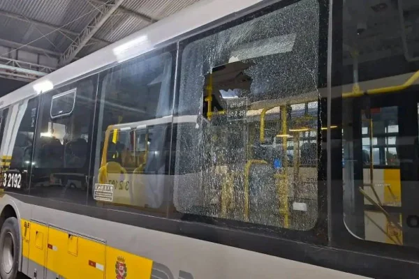 ônibus cinza metálico, com adesivo lateral amarelo, com vidro traseiro quebrado - Metrópoles