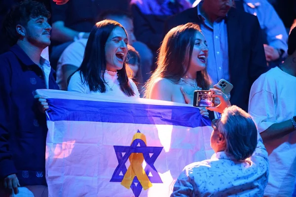Fpto colorida de fãs acenando com a bandeira de Israel enquanto Yuval Raphael, representando Israel, se apresenta durante a 2ª semifinal da Cerimônia de Abertura do 69º Festival Eurovision - Metrópoles