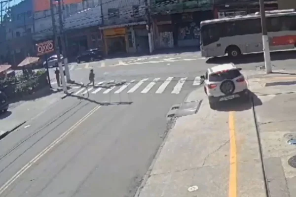 Imagem colorida de mulher passando por faixa de pedestre antes de ser atropelada por ônibus - Metrópoles
