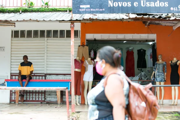 Morodores do entorno com lojas abertas e pessoas na rua