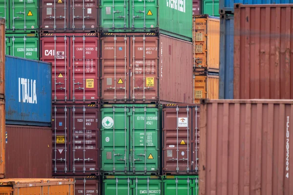 Imagem colorida de containers empilhados em um porto - Metrópoles