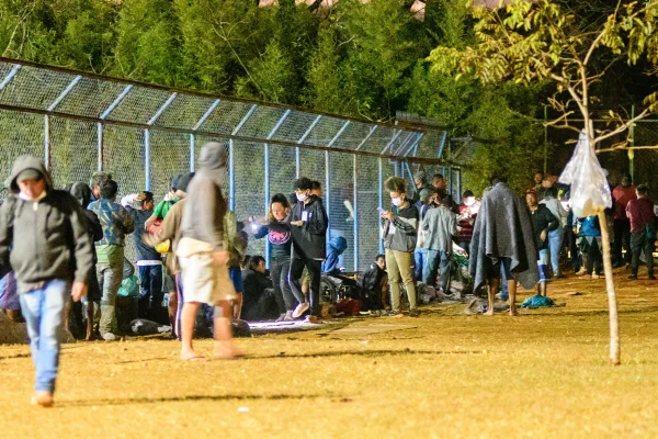 Foto colorida de pessoas em fila de abrigo emergencial do DF