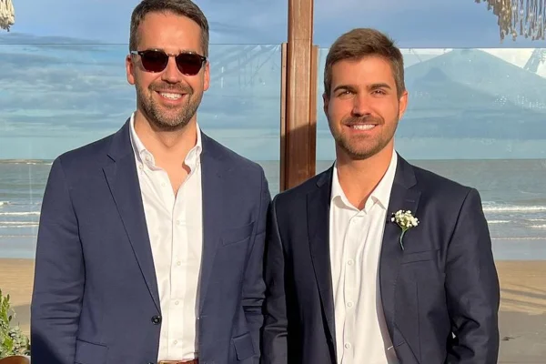 Eduardo Leite e Thalis Bolzan posam juntos e sorridentes - Metrópoles