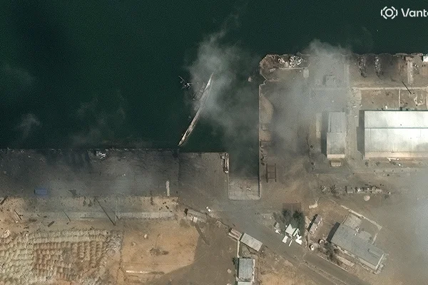 Imagem de satélite em close-up mostra um navio virado com fumaça perto da Base Naval de Konarak, na costa do Irã.